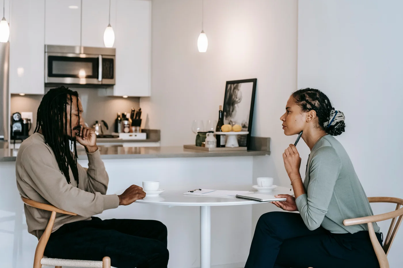 Two adults talking at a table in a home